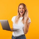 happy woman standing with laptop