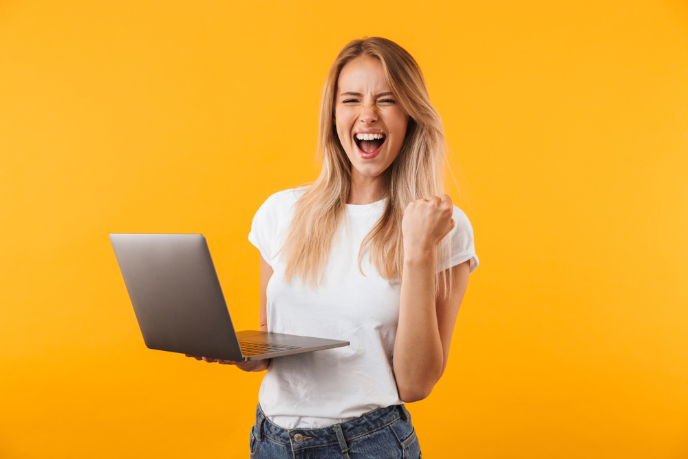 happy woman standing with laptop